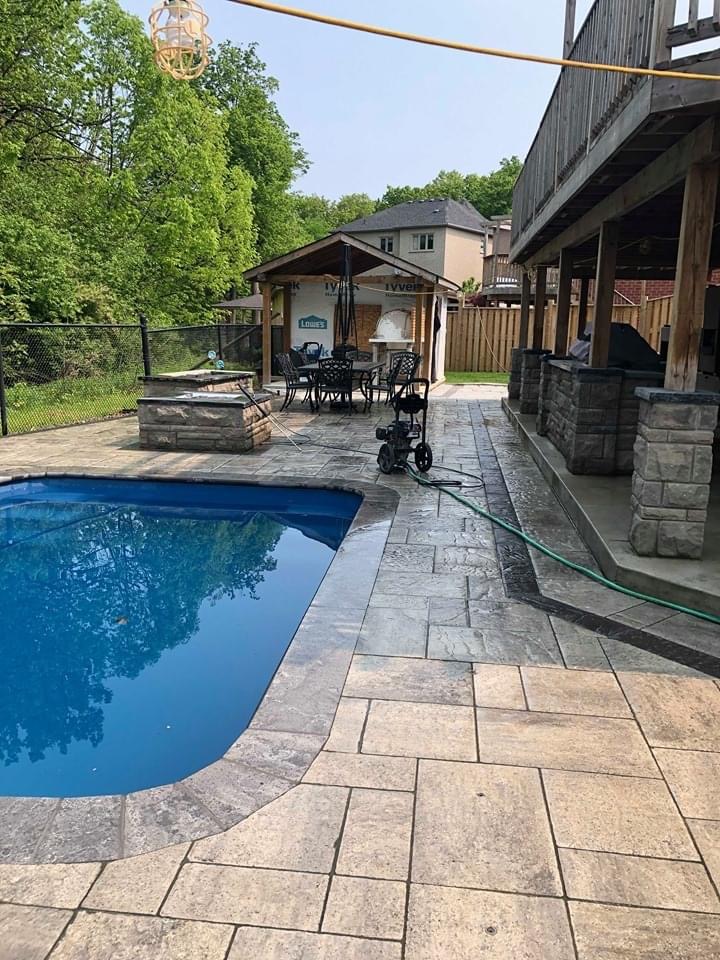 Stamped stone pool deck with covered outdoor kitchen area