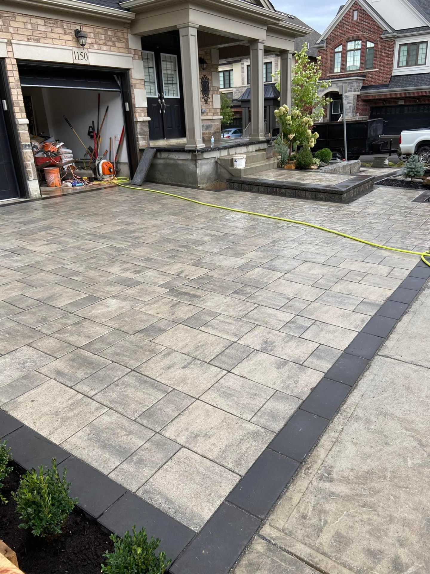 Grey interlock paver driveway with charcoal border banding